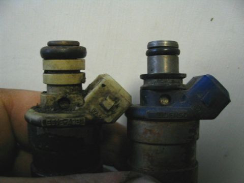 1992 Ford Probe - A close-up view shows two used fuel injectors, one on the left and one on the right.