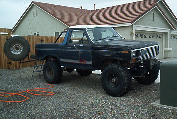 1986 Ford Bronco with spare tire on rear, dark blue with white top