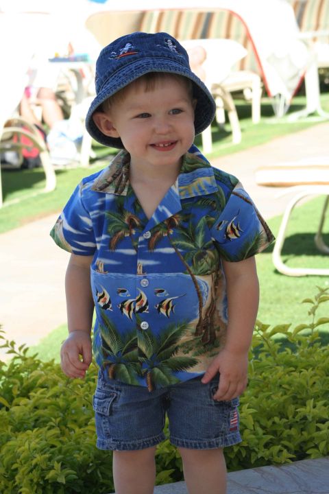 1979 Ford Bronco - A young child smiles while wearing a colorful Hawaiian shirt and denim shorts outdoors.