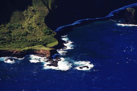1979 Ford Bronco - Aerial view of a coastline with lush green hills meeting the deep blue ocean.