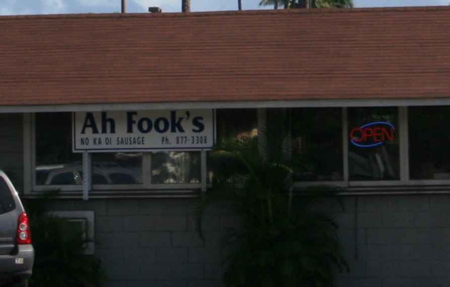 Building exterior with 'Ah Fook's NO KA OI SAUSAGE' sign and an 'OPEN' neon sign