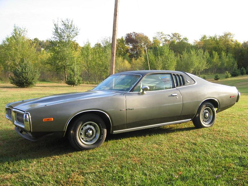 Gray 1970s Dodge Charger coupe parked on grass, side front-quarter view