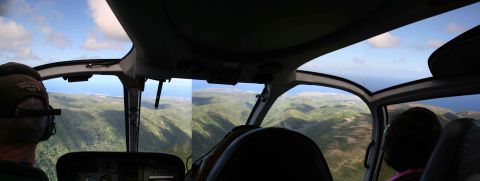 1979 Ford Bronco - View from inside a helicopter cockpit overlooking a mountainous coastline.