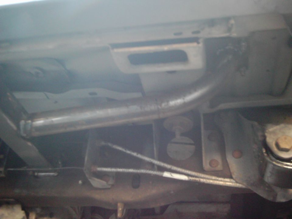 Underside view of vehicle frame with exhaust pipe and suspension components visible