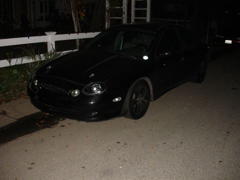 1995 Ford Taurus - Black 1995 Ford Taurus parked on a residential street at night.