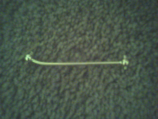 Metal rod with white connectors on a textured background