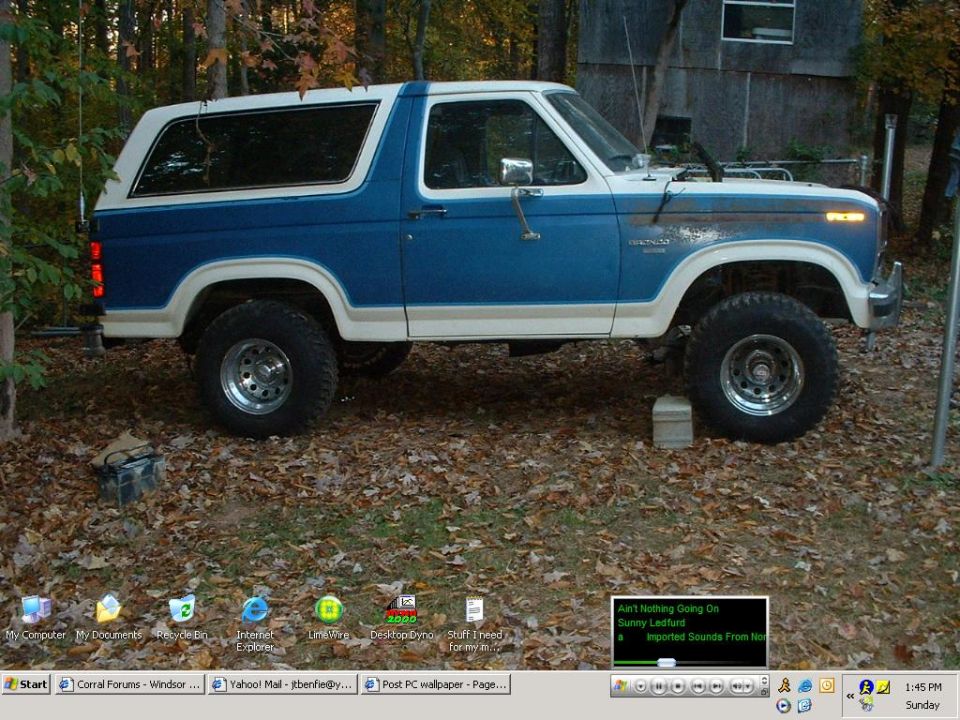 Desktop screenshot of a blue and white full-size Ford Bronco lifted on chrome wheels parked in leaves