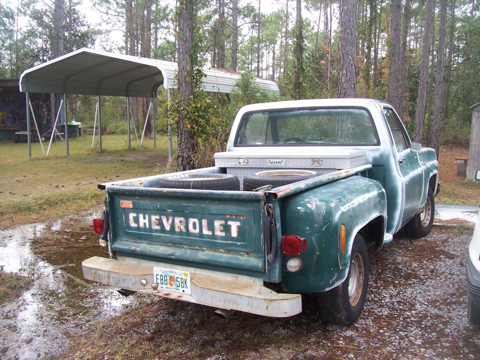 Green Chevrolet pickup truck parked outside with a toolbox in the bed