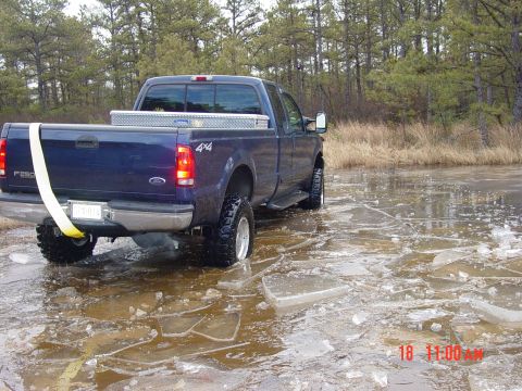 1995 Dodge 1500 - A blue pickup truck navigates through a frozen, icy terrain.