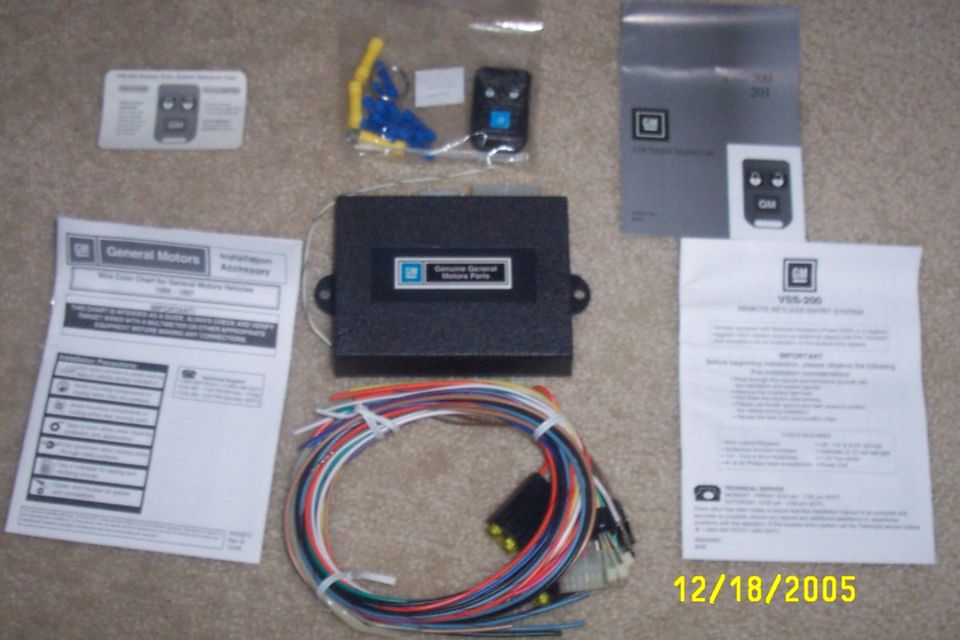 GM VSS-200 keyless entry kit with control module, two remotes, wiring harness, and manuals laid out