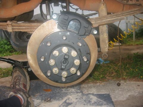 1989 Ford Bronco - Close-up of a vehicle's rear axle brake caliper and rotor assembly during maintenance.