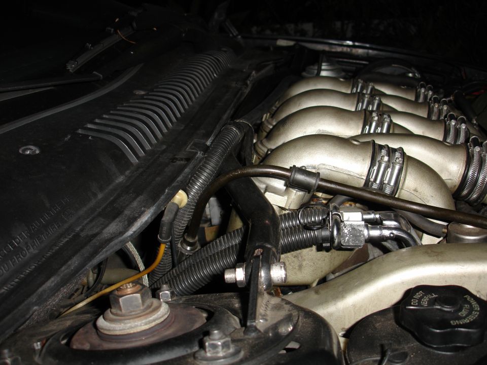 Close-up of a car's engine bay, focusing on the intake manifold and various hoses and wiring