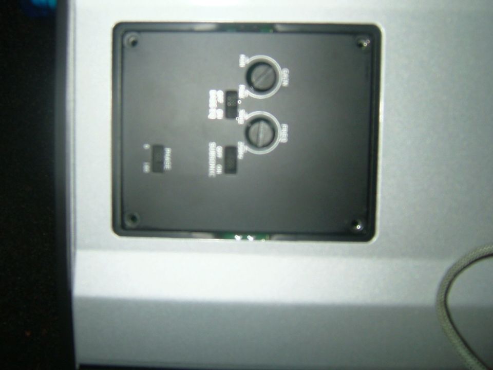 Audio amplifier control panel with two knobs and several switches, one labeled SUBSONIC
