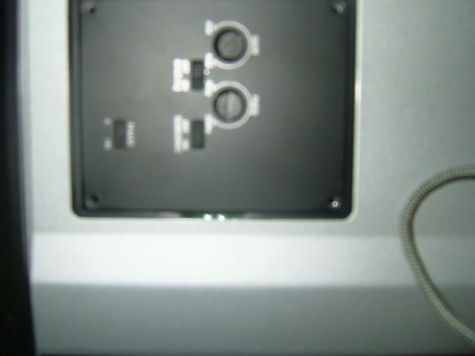 Dashboard panel with four buttons and two circular dials, silver trim, and a coiled cable