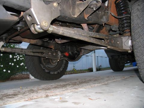 1984 Ford Bronco - Close-up of a vehicle's undercarriage, focusing on suspension and drivetrain parts.