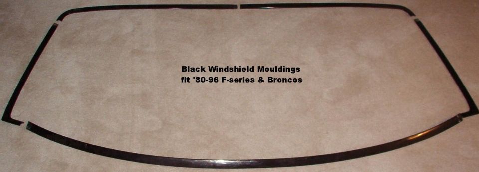 Black windshield mouldings for 1980-1996 Ford F-series and Bronco laid out on carpet