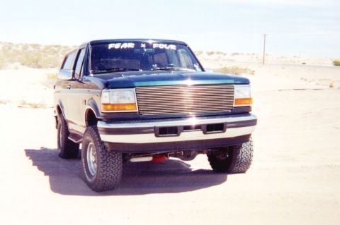 1995 Ford Bronco - This 1995 Ford Bronco is shown in a desert setting with a custom chrome grille and off-road tires.