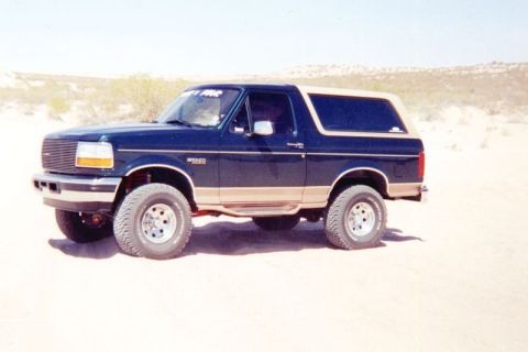 1995 Ford Bronco - This Ford Bronco is parked in a sandy, outdoor environment.