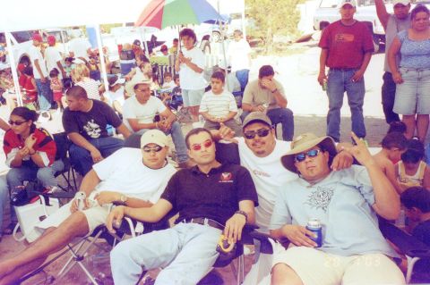 1995 Ford Bronco - People relax at an outdoor event with tents and vehicles visible in the distance.