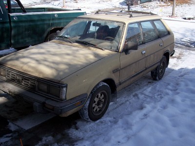 1972 Ford Ranchero - A tan station wagon sits in the snow next to a green truck.