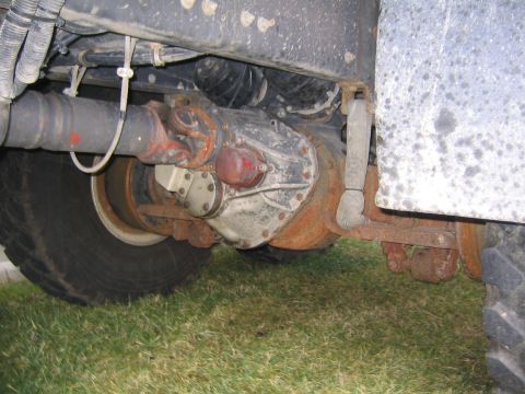1978 Ford Bronco - Close-up of the rear axle assembly and suspension of a heavy-duty vehicle, showing significant wear and rust.