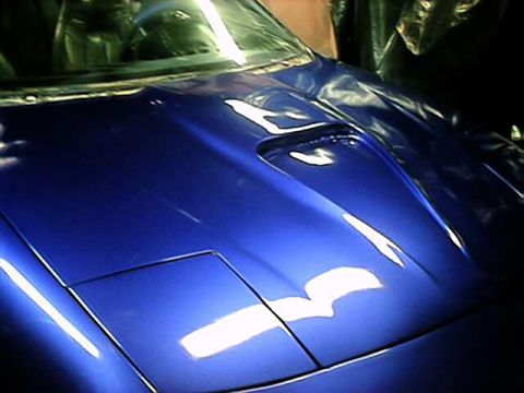 1993 Ford Probe - The hood of a blue 1993 Ford Probe is visible, with a scoop and pop-up headlights.