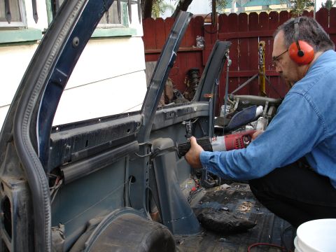 1993 Ford Taurus - Man cuts away car interior structure with a reciprocating saw.