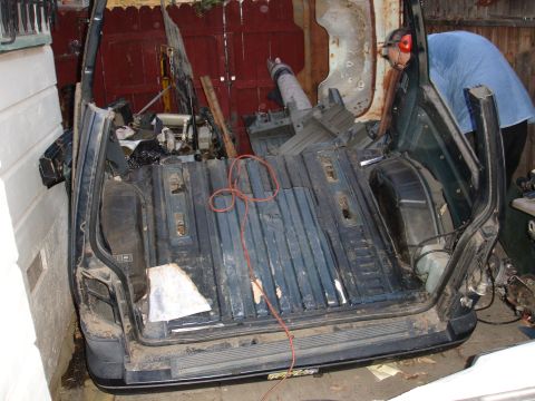 1993 Ford Taurus - The rear interior of a van is shown with its floor stripped and a person visible in the background.