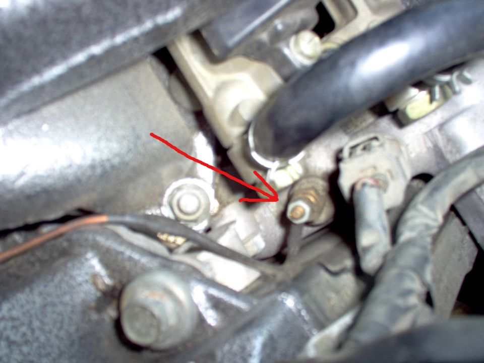 Close-up of an engine sensor with a red arrow pointing to it