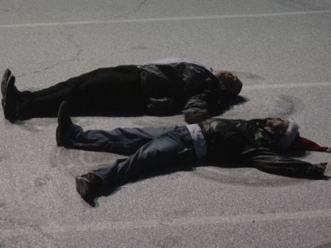1995 Ford Probe - Two individuals are sprawled out on an asphalt surface, with one person sporting a festive Santa hat.