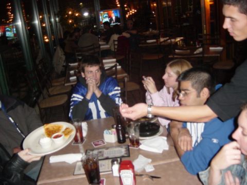 1995 Ford Probe - A group of people are gathered around a table at a restaurant, with food and drinks on the table.