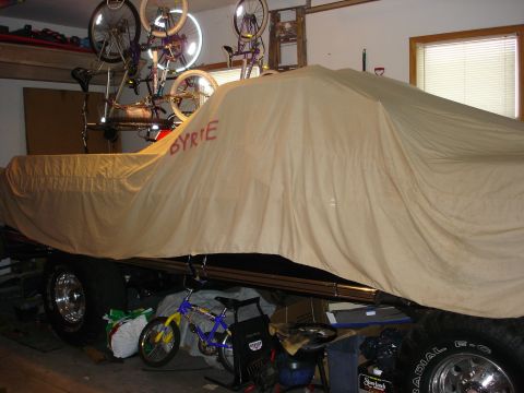 1979 Ford F-250 - A vehicle is covered by a tarp in a garage, with bicycles hanging overhead.