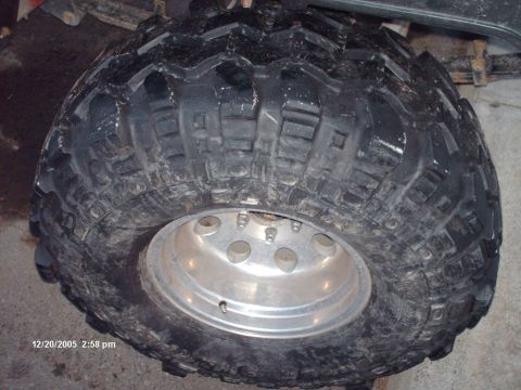1988 Jeep Cherokee - A close-up view of a large, aggressive off-road tire mounted on a polished silver wheel.