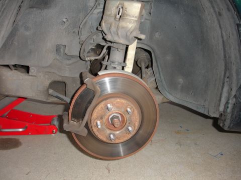 1995 Ford Taurus - Close-up of a car's front brake assembly, showing the rotor and caliper.