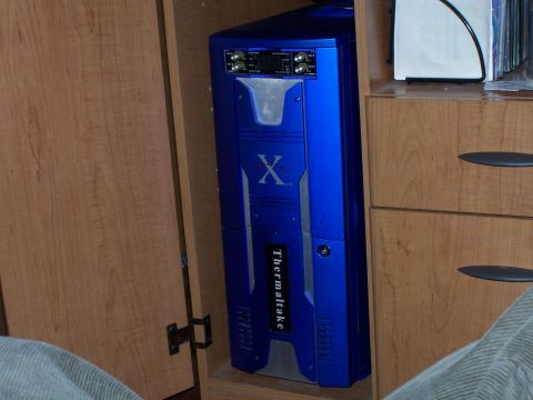 1979 Ford F-150 - A blue Thermaltake computer tower is stored inside a wooden cabinet.