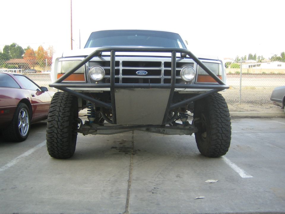 Front view of lifted Ford truck with tube bumper and round driving lights