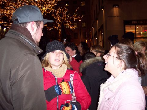 2001 Ford Crown Victoria - A group of people are seen outdoors at night, with decorative lights on trees and buildings visible.
