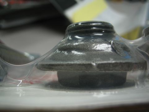 1990 Ford Bronco - low side view of a cone-shaped dark metal part sealed in clear clamshell packaging on a counter.