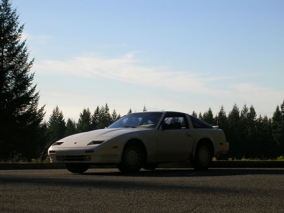 White 1989 Nissan 300ZX parked on asphalt with trees and sky in background