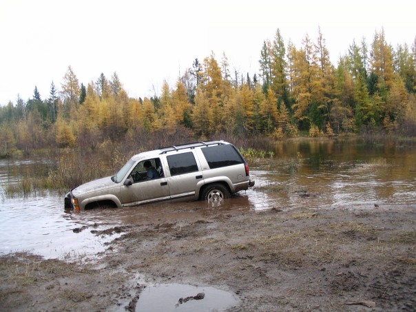 Silver SUV stuck in mud and water, 1995 model year