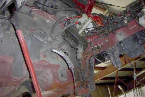 1997 Ford Taurus - Close-up view of the engine bay of a red vehicle, showing exposed wiring and plumbing.
