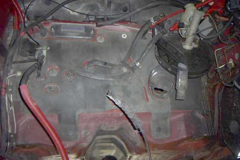 Empty engine bay with brake booster and master cylinder visible