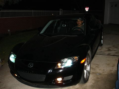 1993 Ford Taurus - Black Mazda RX-8 parked in a driveway at night.