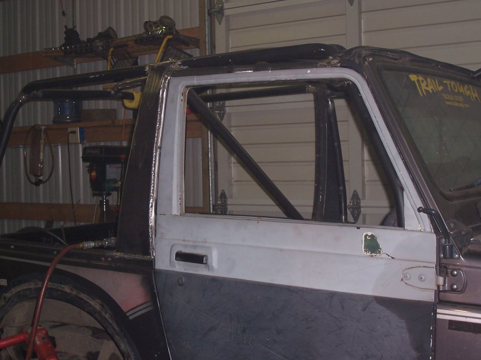 Project SUV with door open and roll cage tubes, 'Trail Tough' decal on rear quarter