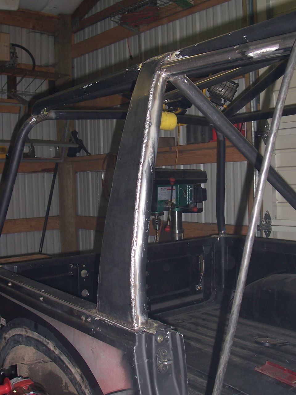 Flat-plated cage upright welded at the bed corner of a project rig in a barn