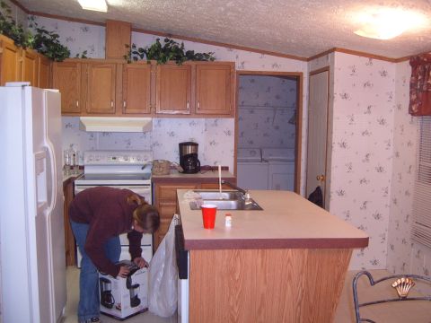 1988 Ford Bronco - A person unpacks a coffee maker in a kitchen that also shows a washer and dryer in the background.