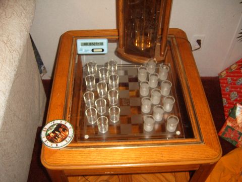 1988 Ford Bronco - A game of checkers is set up using shot glasses on a glass-topped table, with a digital timer nearby.