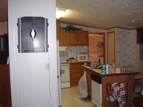 1988 Ford Bronco - This image shows the interior of a kitchen area, wooden cabinets, a countertop, and a dartboard mounted on the wall.