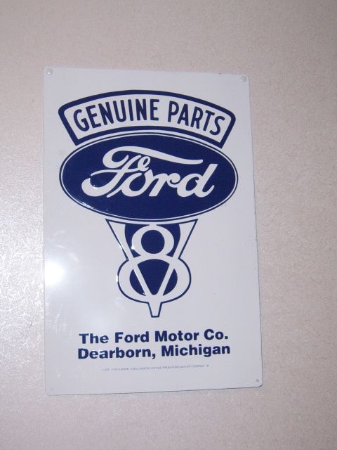 1988 Ford Bronco - A Ford Genuine Parts sign displays the iconic Ford oval logo and V8 emblem, along with company information.