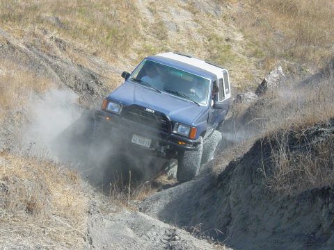 1999 Jeep Grand Cherokee - This SUV navigates a steep, dusty trail, its off-road capabilities.